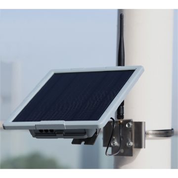 Relais autonome fixé sur un mât : panneau solaire, boîtier étanche et antenne verticale.